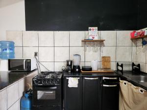 a kitchen with a black stove and a microwave at Mini Hostel no centro de Tutoia in Tutóia