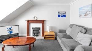 a living room with a couch and a table at Bute Seaview in Rothesay