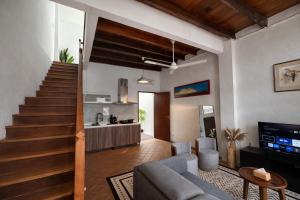 a living room with a couch and a staircase at Courtyard by Heritage Row in George Town