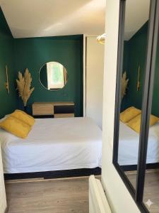 a small room with two beds and a mirror at Studio les Hauts de Honfleur in Équemauville +8 photos