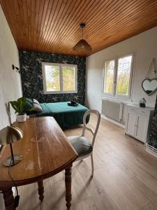 a living room with a table and a bed at Maison chaleureuse de village - location logement entier in Lanans