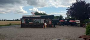a food stand with tables and umbrellas in a field at Tåsinge camping og Grill in Svendborg