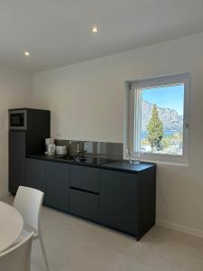 a kitchen with black cabinets and a large window at Casa Nane in Malcesine
