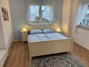 a bedroom with a bed and two windows at Ferienwohnung Heinrichshofen in Heinrichshofen