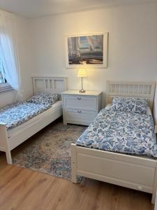a bedroom with two beds and a table with a lamp at Ferienwohnung Heinrichshofen in Heinrichshofen +4 photos