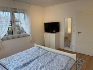 a bedroom with a bed and a flat screen tv at Ferienwohnung Heinrichshofen in Heinrichshofen