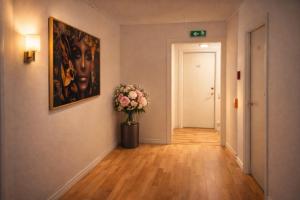 a hallway with a painting and a vase of flowers at City Living Trelleborg in Trelleborg +1 photo