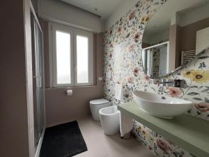 a bathroom with a sink and a toilet and a mirror at Appartamento Ideal con piscine e animazione Hotel Alba d Oro estate in Gatteo a Mare