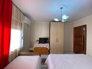 a bedroom with two beds and a dresser and a bed at Kruja Apartment SA in Krujë