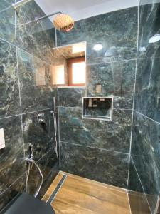 a bathroom with a large black marble shower at Kruja Apartment SA in Krujë