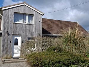 a building with a white door and a window at Tom's Alpaca Cottage in Mooncoin