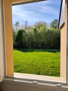 a window with a view of a field of grass at Studio les Hauts de Honfleur in Équemauville