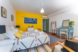 a bedroom with a large bed and a desk at A-Típica GuestHouse in Ponta Delgada