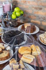 a table topped with plates of pastries and bread at Hotel Bela Vista Palace in Araçariguama