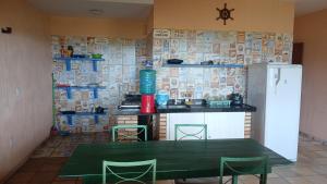 a kitchen with a green table and a refrigerator at Flat Casa Taiba 2002 in São Gonçalo do Amarante +3 photos