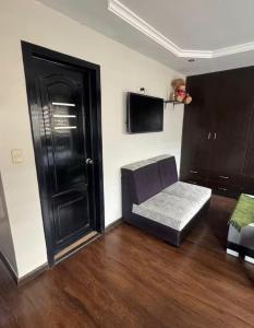a living room with a couch and a black door at Or King in Cuenca
