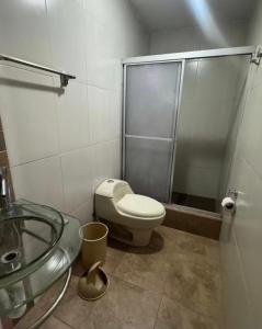 a bathroom with a toilet and a glass shower at Or King in Cuenca