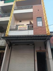 a building with a garage door with a sign on it at आदिनाथ गेस्ट हाउस in Ujjain