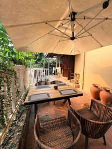 a patio with a table and chairs and an umbrella at 喜悦民宿 Joy in Luang Prabang