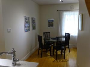 a dining room with a table and chairs and a window at villa du vignoble in Dunham