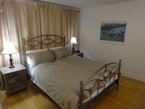 a bedroom with a large bed and two lamps at villa du vignoble in Dunham