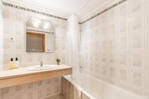 a white bathroom with a sink and a tub at Sardonyx Scape Madeira Close to Garajau Funchal in Caniço +30 photos