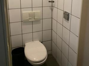 a bathroom with a white toilet and a trash can at Lakes Small in Kaag