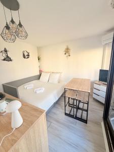 a hotel room with a bed and a table at Terrasse vue Etang, piscine Séjour détente in Le Barcarès