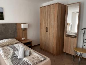 a bedroom with a bed and a wooden cabinet at Ferienhof Schäfer in Oberderdingen