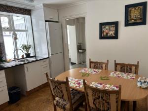 a kitchen with a wooden table with chairs and a refrigerator at Spacious Apartment -Top Location in Akureyri