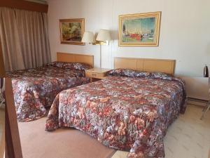 a hotel room with two beds in a room at Alberni Inn in Port Alberni