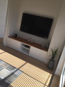 a living room with a flat screen tv on a wall at l'Intervalle in Mont-Saint-Guibert
