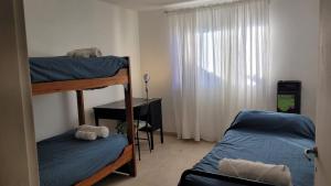 a bedroom with two bunk beds and a window at Depto Diucon Centro in Esquel