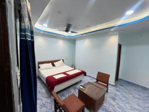 a bedroom with a bed and a table and chairs at Hotel Golden Palace in Chhatarpur