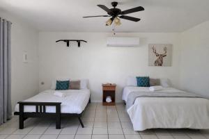a room with two beds and a ceiling fan at Dorado Costa De Oro Beach 2 Bedroom Oceanfront by Rentalspr in Dorado
