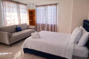 a bedroom with a white bed and a couch at Dorado Costa De Oro Beach 2 Bedroom Oceanfront by Rentalspr in Dorado