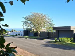 a road with a house and a tree on the side at Blue Bend Valley in East London