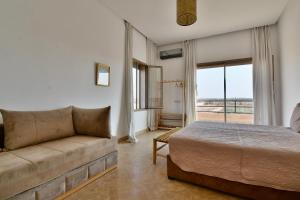 a bedroom with a couch and a bed and a window at Dar Sofia Villa in Marrakesh +128 photos