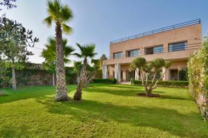 a building with palm trees in front of it at Dar Sofia Villa in Marrakesh