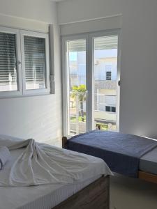 a bedroom with two beds and two windows at Veloura in Ulcinj