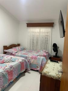 a bedroom with two beds and a window at Casa Roldanillo in Roldanillo