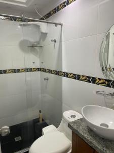 a bathroom with a toilet and a sink and a mirror at Casa Roldanillo in Roldanillo