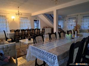 a dining room with a long table and chairs at Pensiunea Maramu in Breb