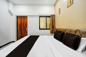 a bedroom with a large bed and a window at Hotel O katyayani in Indore
