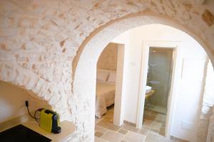 a room with a stone wall with a yellow appliance on a counter at Campanile Inn in Locorotondo +45 photos