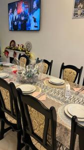a dining room table with plates on it with a tv at Pensiunea Maramu in Breb