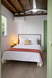 a bedroom with a large white bed with a ceiling at Bibi Beach Sunrise in La Trinité