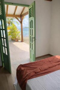 a bedroom with an open door to the beach at Bibi Beach Sunrise in La Trinité