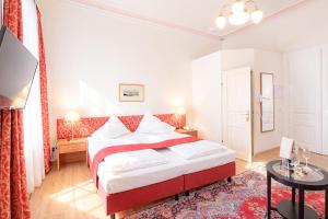 a bedroom with a red and white bed and a table at HPA Hotel Andreas in Vienna