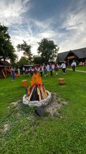 a group of people standing around a fire pit at Pensiunea Maramu in Breb